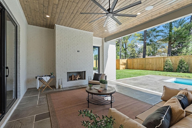 view of patio featuring an outdoor living space with a fireplace, ceiling fan, and a fenced backyard