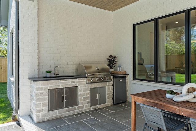 view of patio / terrace with an outdoor kitchen, a sink, and area for grilling