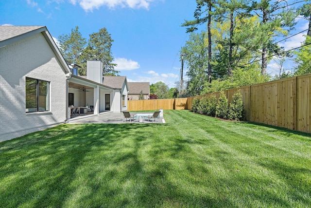 view of yard with ceiling fan, a fenced backyard, and a patio