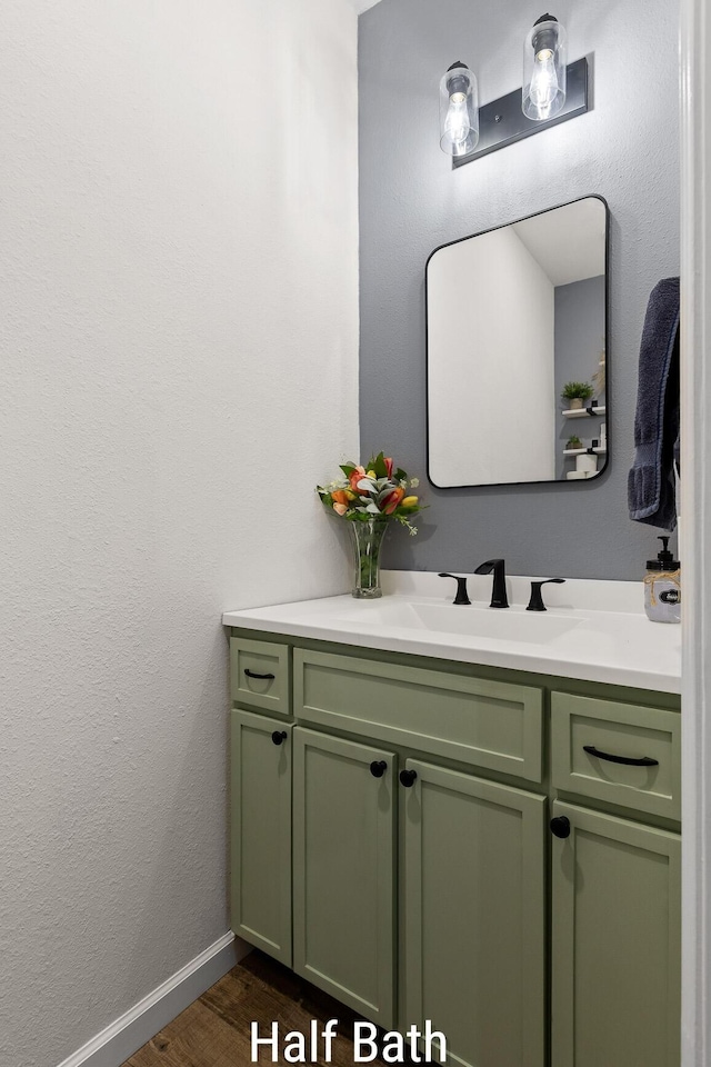 bathroom with wood finished floors, vanity, and baseboards