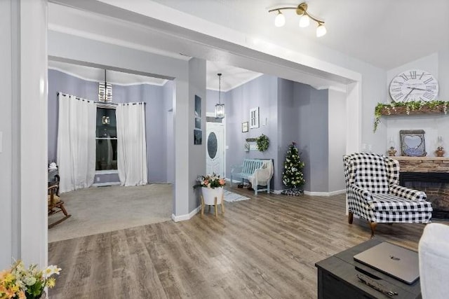 living area with a notable chandelier, baseboards, and wood finished floors