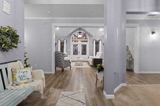 interior space featuring crown molding, baseboards, and wood finished floors