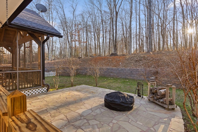 view of patio featuring fence and a sunroom