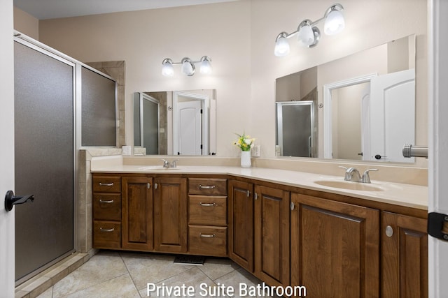 bathroom featuring tile patterned floors, double vanity, a sink, and a stall shower