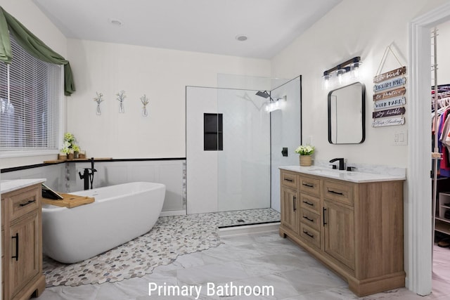 full bathroom featuring a freestanding tub, vanity, marble finish floor, wainscoting, and walk in shower