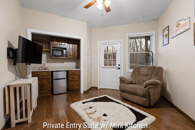 bar featuring ceiling fan, dark wood finished floors, refrigerator, baseboards, and built in microwave