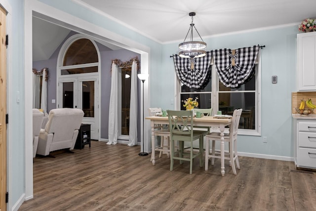 dining space featuring a chandelier, baseboards, ornamental molding, and wood finished floors