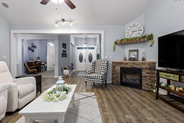 living room with baseboards, a ceiling fan, wood finished floors, and a fireplace