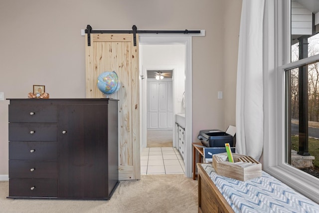 bedroom with light carpet, light tile patterned floors, and ensuite bath
