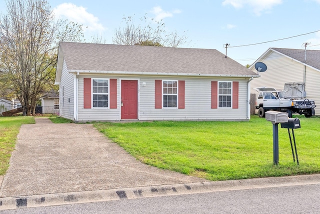 view of front of house featuring a front yard and a shingled roof