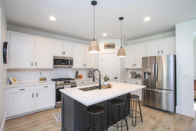 kitchen featuring decorative backsplash, appliances with stainless steel finishes, a sink, and white cabinets