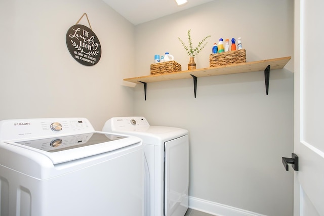 clothes washing area featuring separate washer and dryer, baseboards, and laundry area