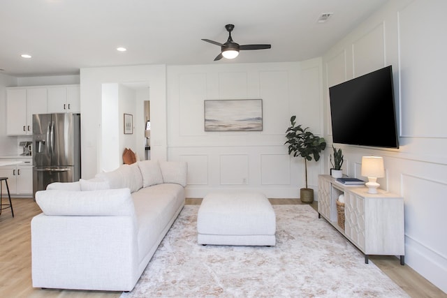 living room featuring recessed lighting, a ceiling fan, visible vents, and light wood-style flooring