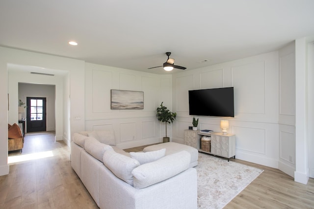 living room with light wood-style flooring, visible vents, recessed lighting, ceiling fan, and a decorative wall