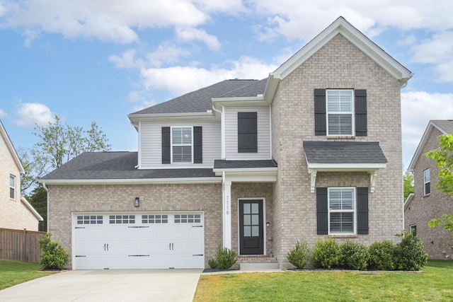 traditional home featuring a front lawn, driveway, fence, a garage, and a shingled roof