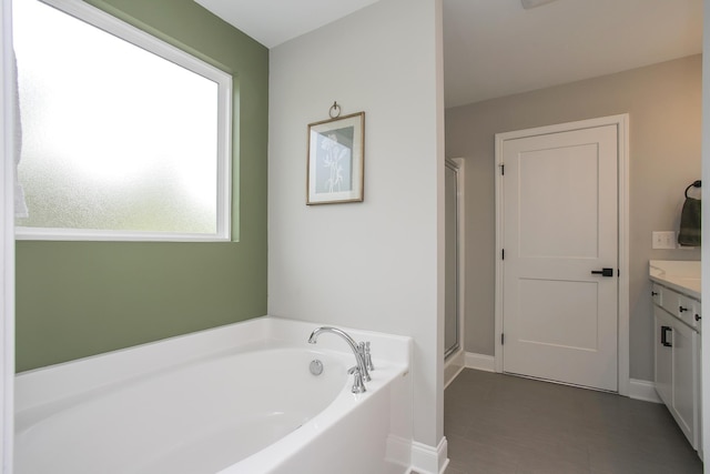 full bathroom featuring baseboards, a bath, vanity, and a stall shower