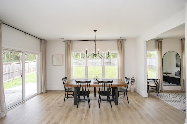 dining room featuring baseboards, a chandelier, and light wood-style floors