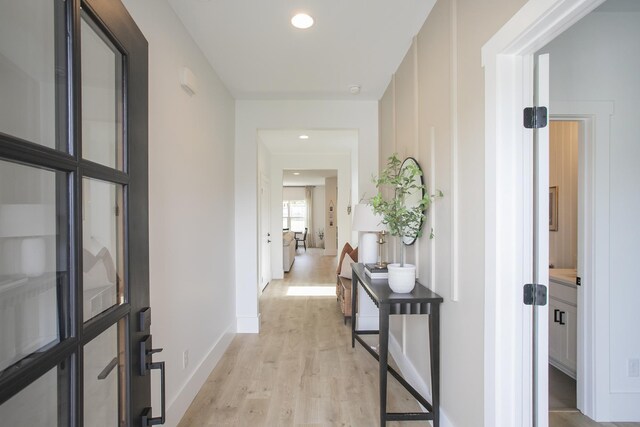 hallway with recessed lighting, baseboards, and light wood-style flooring