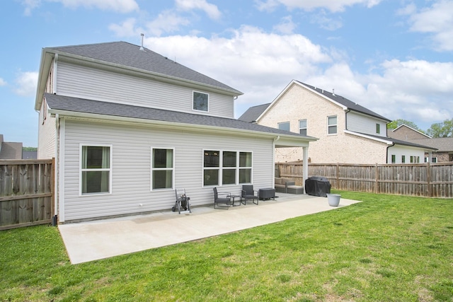 rear view of property featuring a lawn, a patio, and a fenced backyard