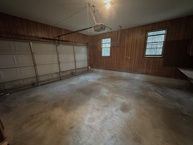 garage with a garage door opener and wooden walls