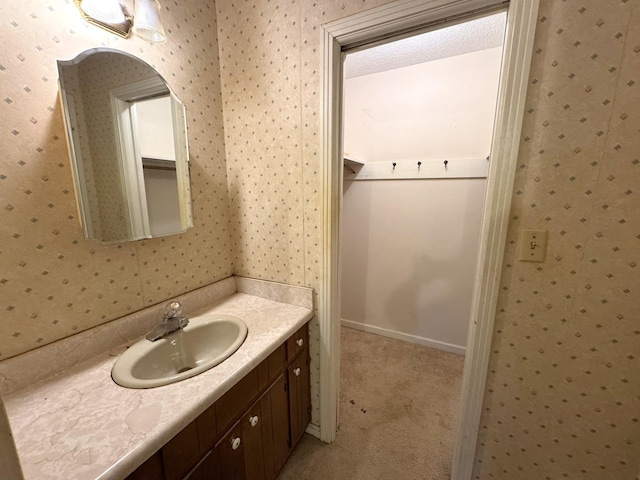 bathroom with vanity and wallpapered walls