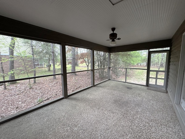 unfurnished sunroom with a ceiling fan and a healthy amount of sunlight