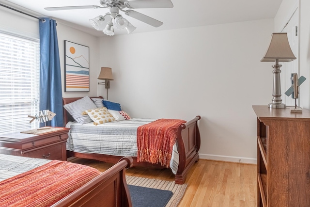 bedroom with baseboards, light wood-type flooring, and a ceiling fan