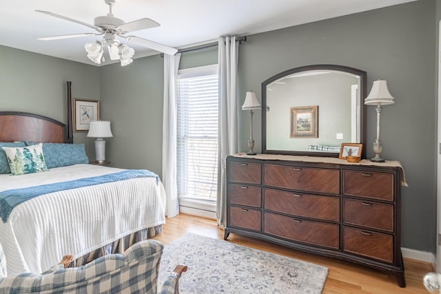 bedroom featuring light wood finished floors, baseboards, and a ceiling fan