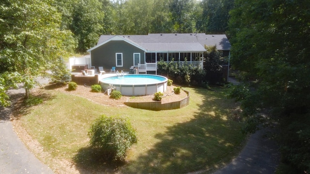 pool featuring a sunroom and a lawn