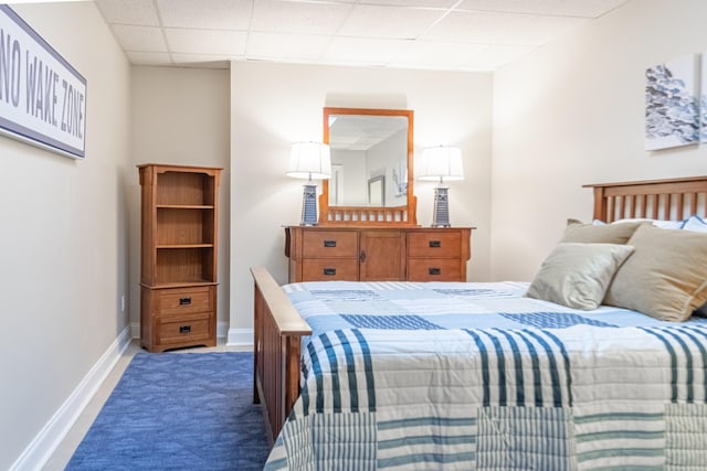 bedroom featuring baseboards and a drop ceiling