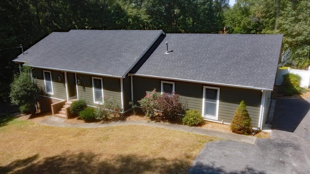 single story home with a front yard and a shingled roof