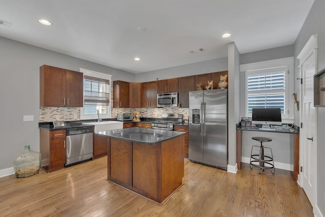 613 Chesterfield Way, Nashville, TN 37212 - kitchen with dark countertops, light wood-type flooring, decorative backsplash, and appliances with stainless steel finishes