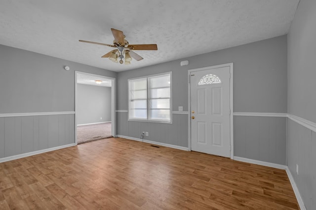 1425 Wesley Rd, Bon Aqua, TN 37025 - entrance foyer with visible vents, a wainscoted wall, a ceiling fan, and wood finished floors