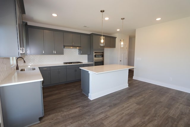 kitchen with dark wood-type flooring, stainless steel double oven, gas stovetop, and a sink