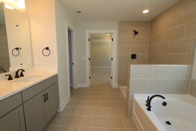 bathroom with tile patterned floors, a bath, a tile shower, baseboards, and visible vents
