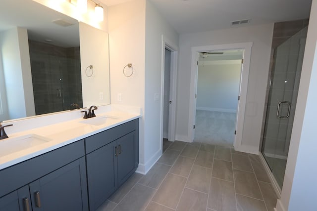 bathroom with visible vents, a sink, a shower stall, and double vanity