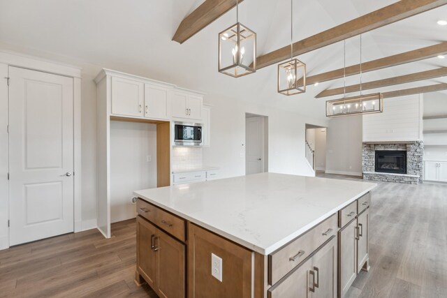 7930 Pine St, Fairview, TN 37062 - kitchen featuring hanging light fixtures, wood finished floors, stainless steel microwave, and a kitchen island