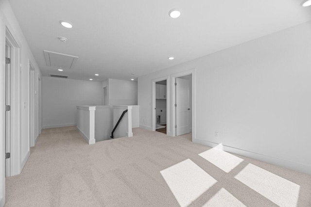 empty room featuring attic access, baseboards, recessed lighting, and light colored carpet