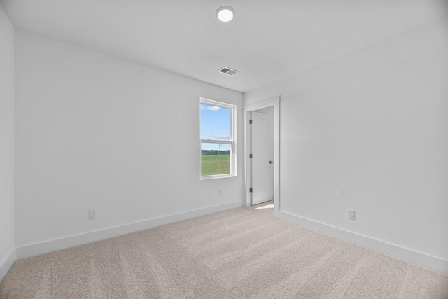 spare room featuring visible vents, carpet flooring, and baseboards