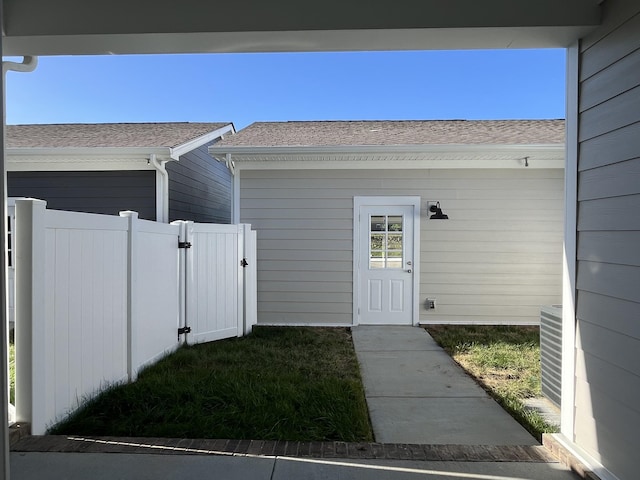 view of exterior entry featuring fence and a gate