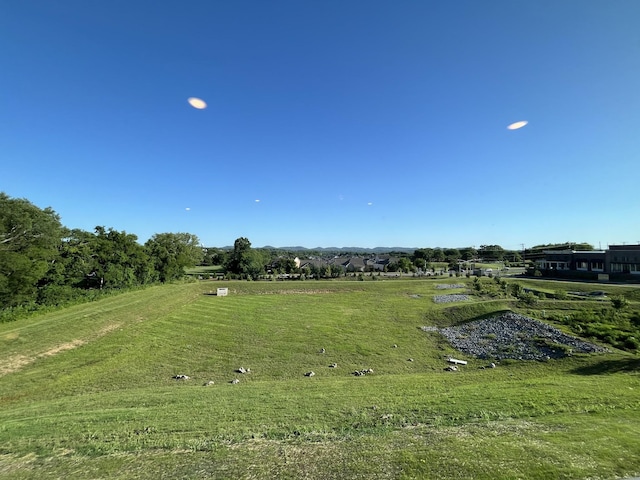 view of property's community with a lawn and a rural view