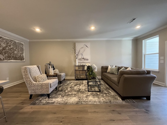 living area featuring crown molding, wood finished floors, baseboards, and visible vents