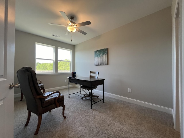 carpeted home office with ceiling fan, baseboards, and visible vents