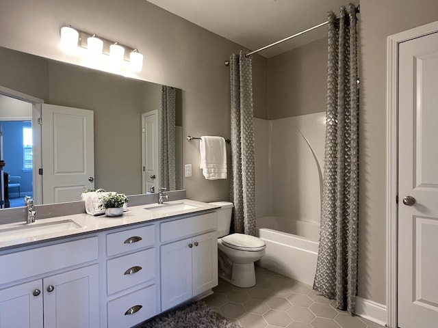 full bath featuring tile patterned flooring, double vanity, a sink, and toilet