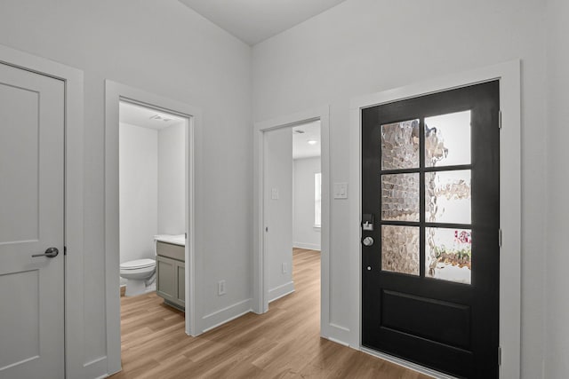 foyer entrance featuring baseboards and light wood finished floors