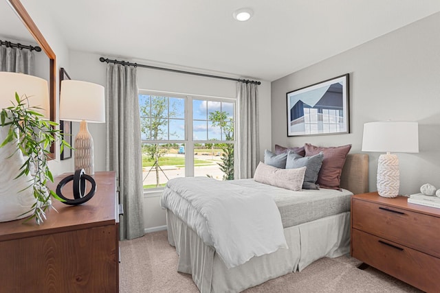 bedroom with baseboards and light carpet