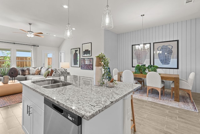 kitchen featuring white cabinets, a sink, a center island with sink, ceiling fan with notable chandelier, and dishwasher