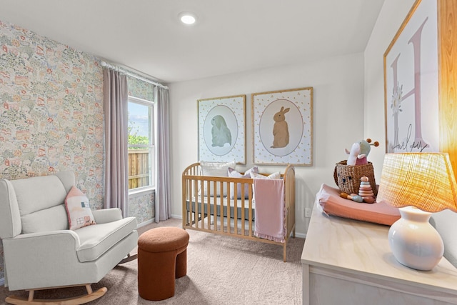 bedroom featuring carpet floors, a crib, and baseboards