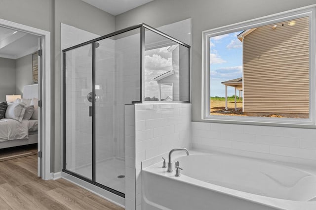 bathroom featuring a shower stall, connected bathroom, wood finished floors, and a garden tub