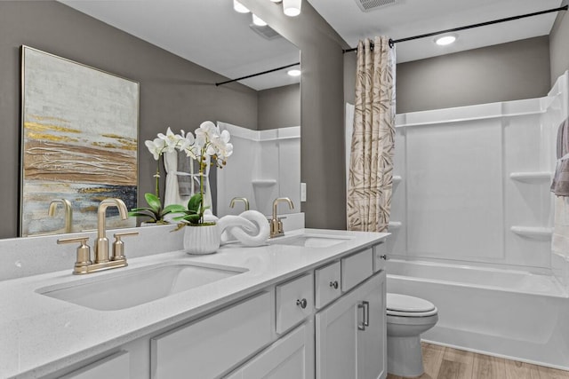 bathroom featuring a sink, shower / tub combo, toilet, and wood finished floors